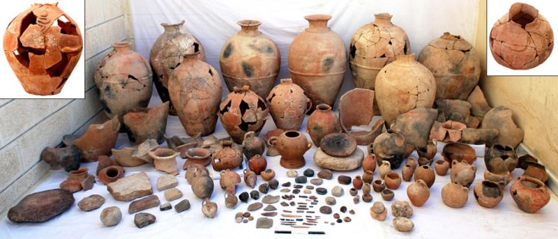 Fig. 27. The assemblage from Pillared Hall (L.1040) in Palace B at Khirbet al-Batrawy (Zarqa), which includes pithoi, red-burnished jugs and pointed juglets, medium-sized jars, ceremonial vessels with applied decorations of snakes and scorpions, and noteworthy objects, among which are a bone knife and several worked bones, pierced seashells, and a carefully worked basalt potter's wheel (L. Nigro).