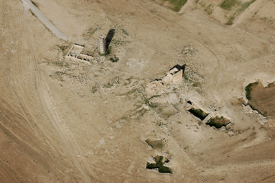 Fig. 4. Byzantine tower 1.5 km north of the major Roman and Byzantine fort and town of Umm er-Resas. In this view, looking northeast, one can see the tower (scaffolded for restoration) with associated rectangular enclosure; the church on its northwest side (left); and, to the south, a second complex of well-preserved structures. Further south (bottom right quadrant) is a group of quarries, some later converted for water storage.